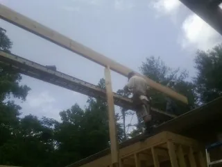 Carpenter setting a ridge beam over a new addition frame — Ice Dam Removal by Roofing Brothers in Mosheim