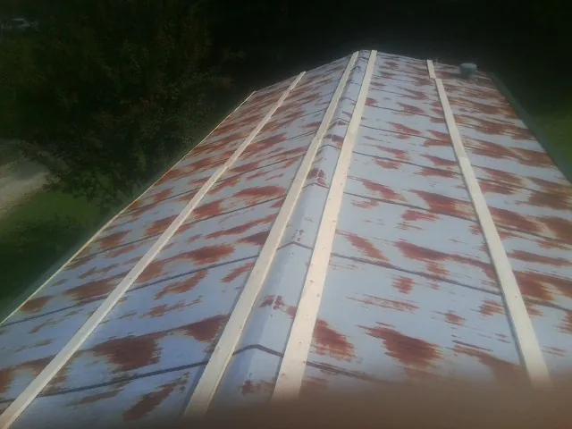 Rusted metal roof panels with new wood purlins before replacement — Storm Damage Roof Repair in Mosheim by Roofing Brothers
